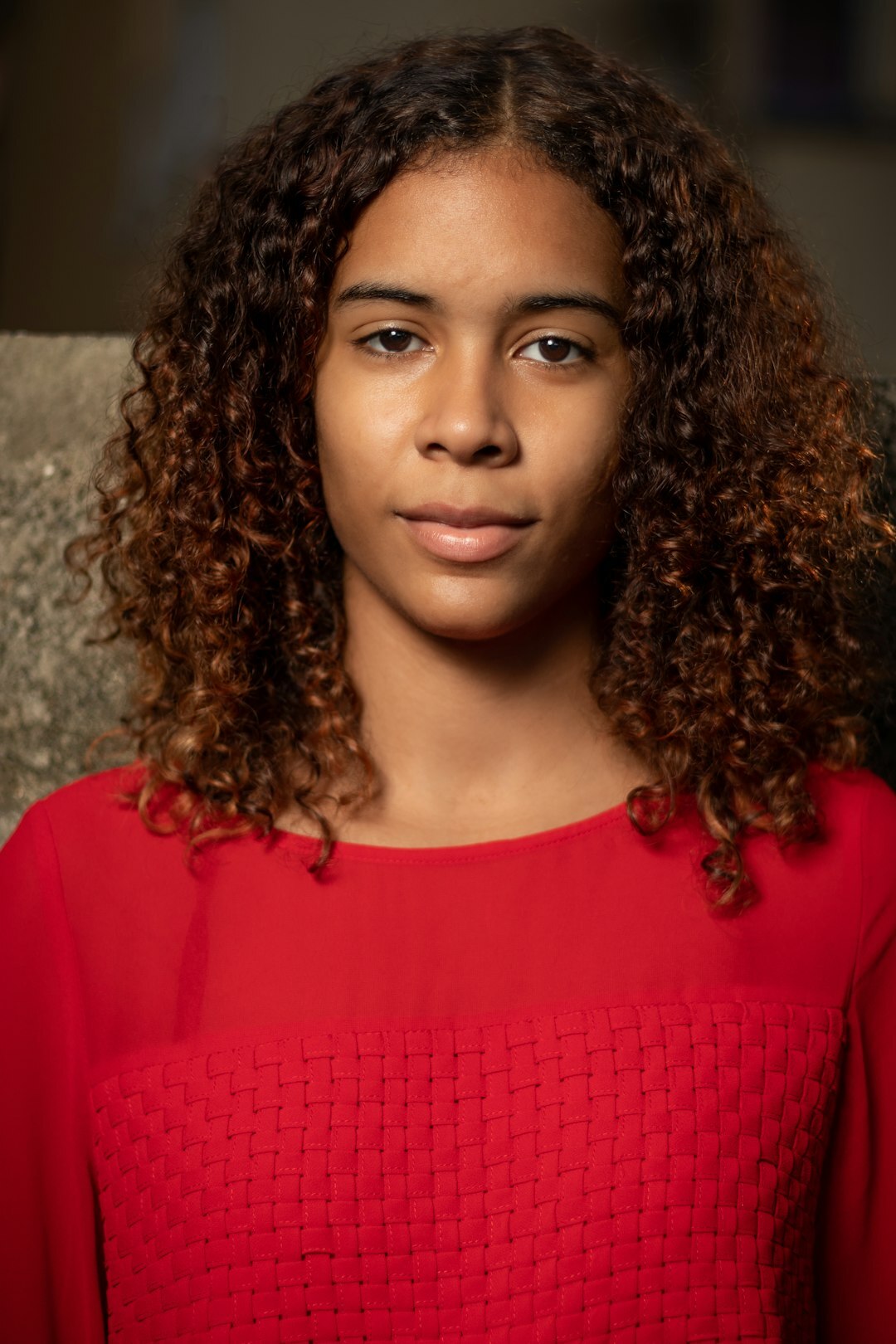 Studio headshot of a woman with curly hair