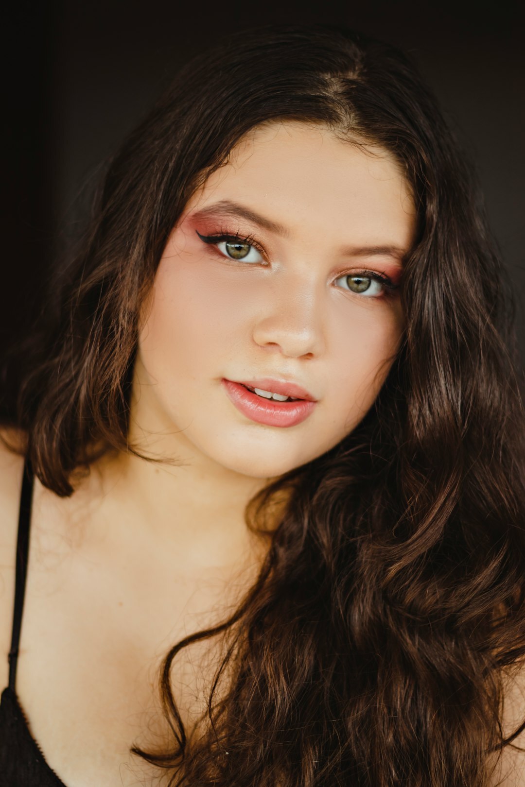 Studio headshot of a young woman with dark hair